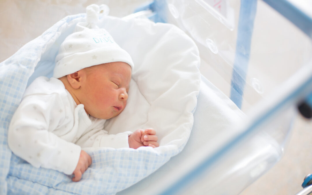 Newborn baby laying in crib in prenatal hospital